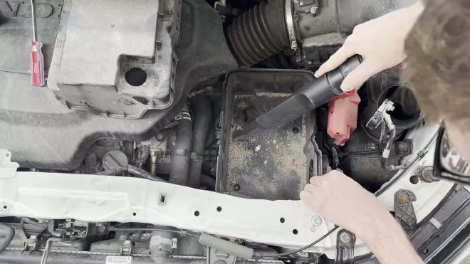 Vacuuming dirt and debris from the Honda Odyssey battery tray