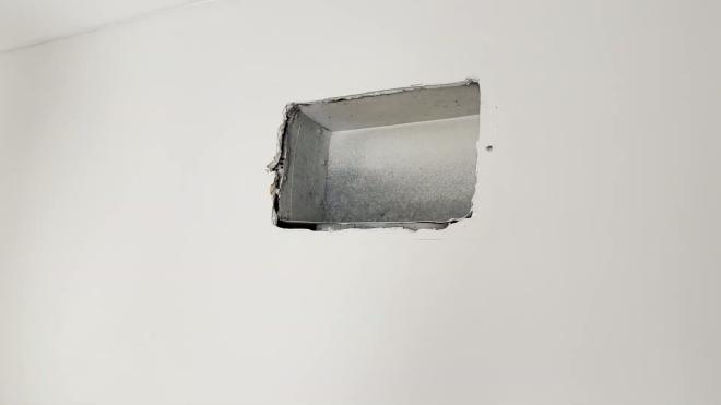 Wall register opening before installing the booster fan
