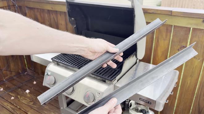 Two cut pieces of steel angle held in front of the grill