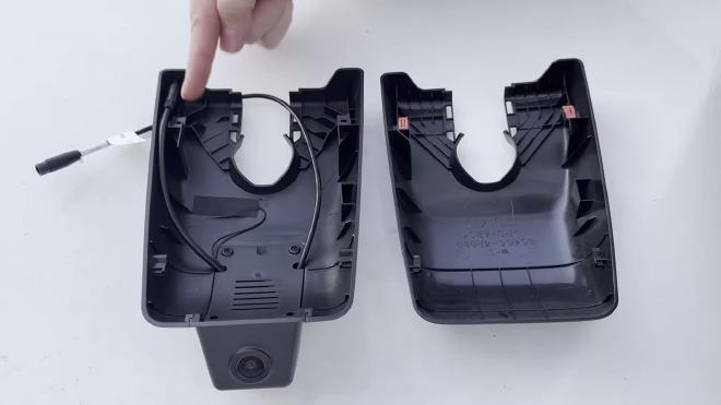 Factory mirror cover and FITCAMX housing side by side, with the orange clips still on the original cover