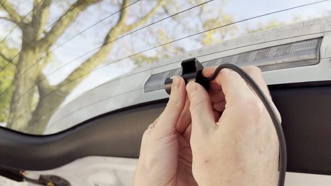 Pressing the FITCAMX rear camera onto the top center of the rear glass