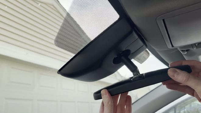 Tilting the Toyota RAV4 rearview mirror down before removing the cover