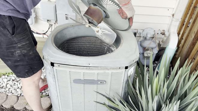 Lifting the Trane XR12 fan assembly off the outdoor unit