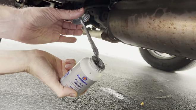 Applying anti-seize lubricant to the Toyota RAV4 heat shield mounting stud
