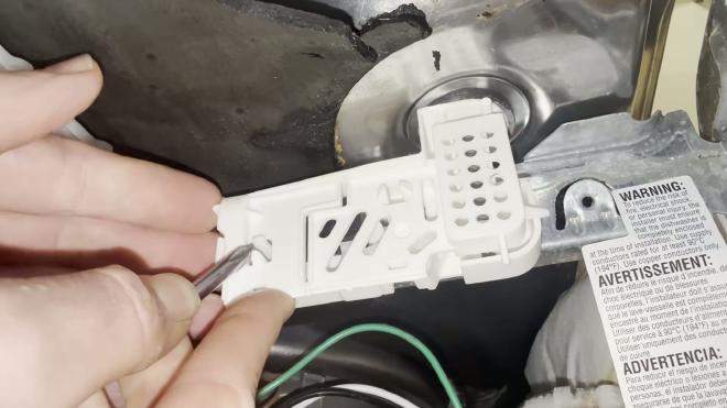 Releasing the tabs on the Whirlpool float switch housing