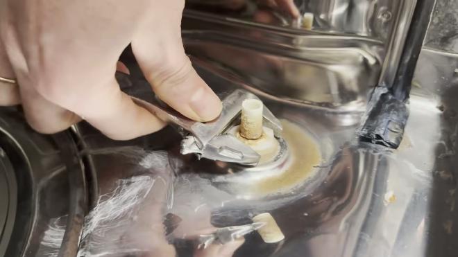 Unscrewing the plastic nut that holds the float housing