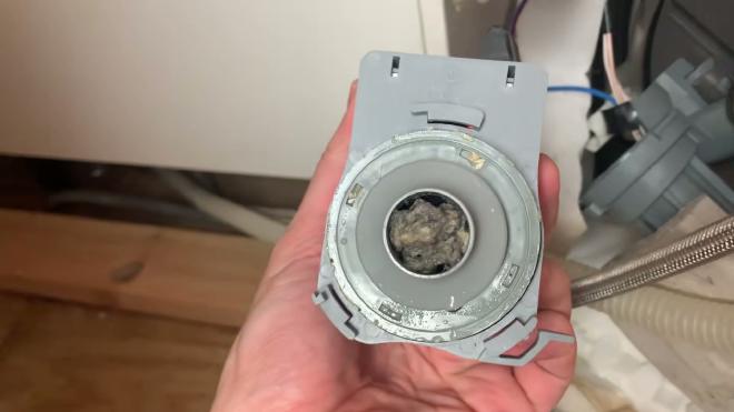 Clogged Whirlpool dishwasher circulation pump packed with debris