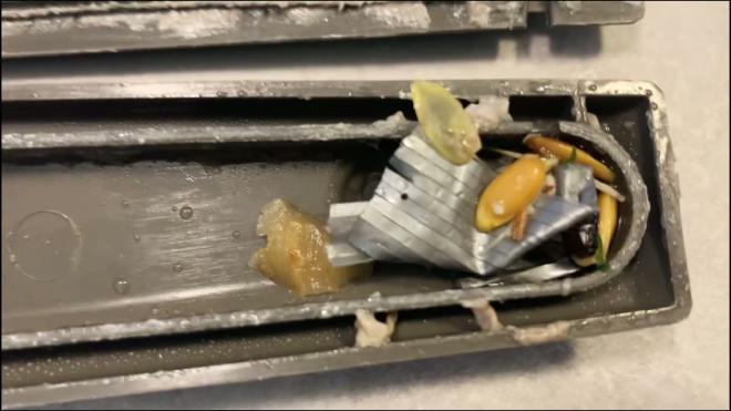 Food debris clogging the inside of the Whirlpool dishwasher spray arm