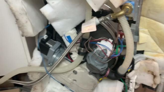 Underside of the Whirlpool dishwasher with the circulation pump visible